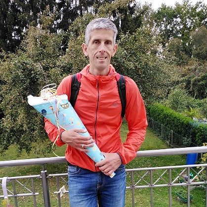 Erwachsener Mann schaut mit Schultüte in die Kamera