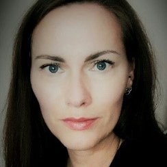 Schwarzhaarige Frau schaut konzentriert Richtung Betrachter; Bild mit Vignette