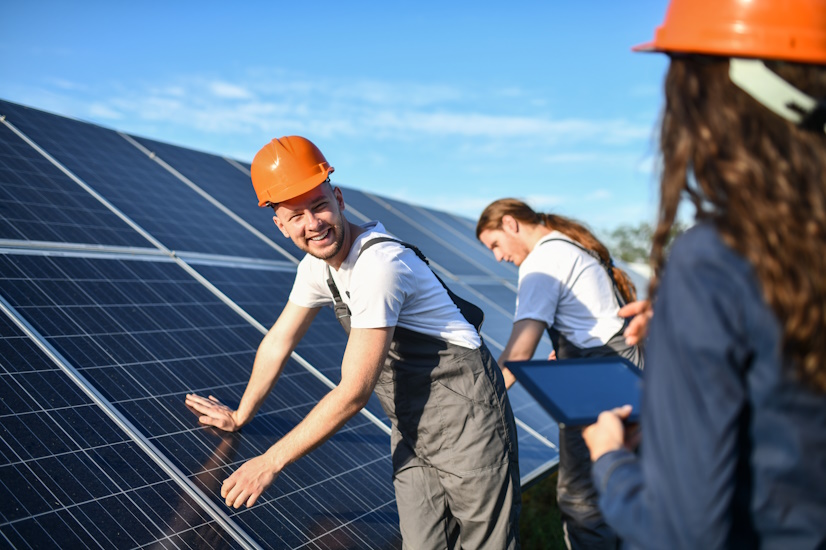 Mann stützt sich an Photovoltaikanlage ab
