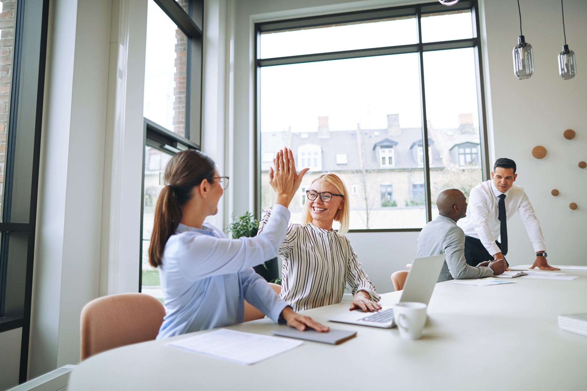 2 Frauen geben High-Five und geben Infos über uns